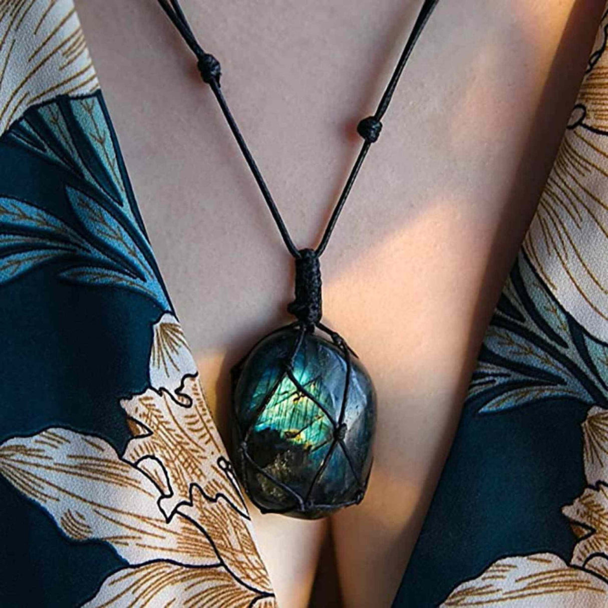 Colier cu cristal Labradorit in forma ovala, infasurat intr-o plasa de franghie neagra - o piatra semipretioasa pentru meditatie, intuitie, imaginatie
